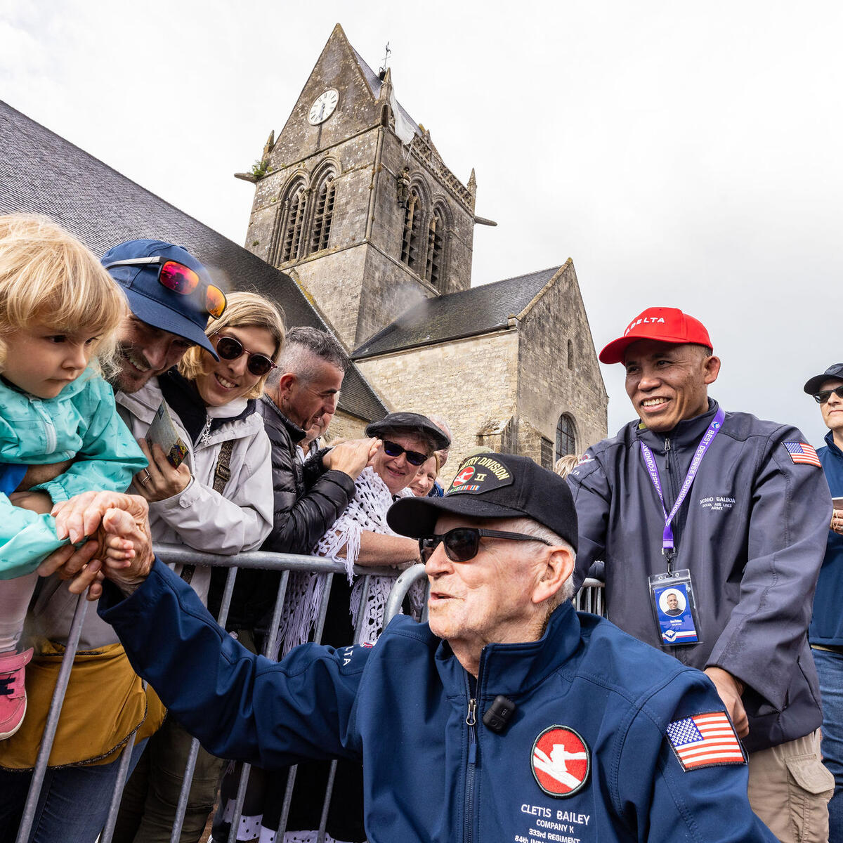 Delta’s Noni Balboa escorts Cletis Bailey through a parade in St. Mere Eglise.