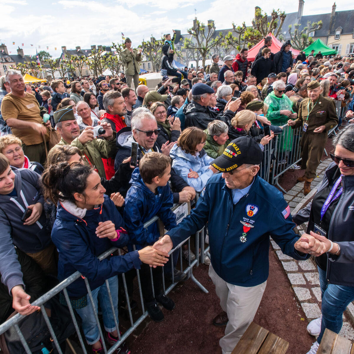 Delta’s Carmela Carter escorts World War II veteran Wally King through a parade in St. Mere Eglise.