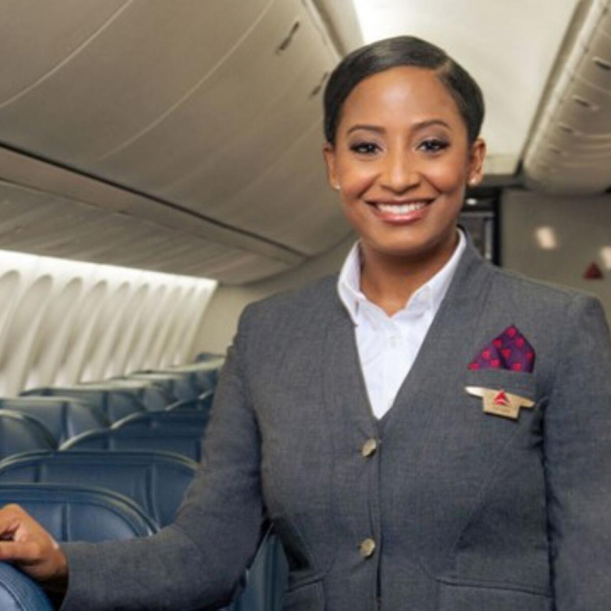 Delta flight attendant in grey uniform onboard aircraft