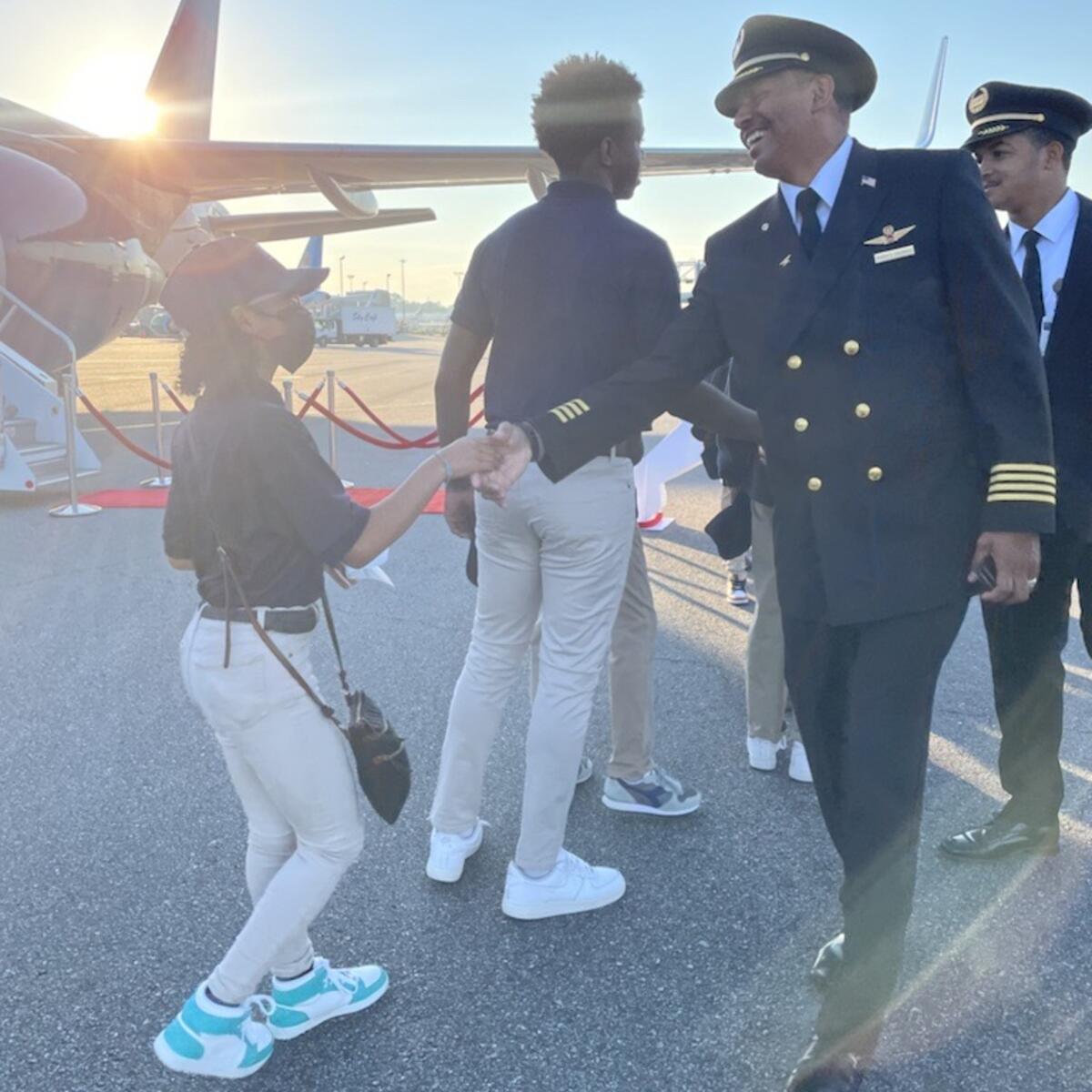A Delta pilot greets a student participating in the 2022 Dream Flight