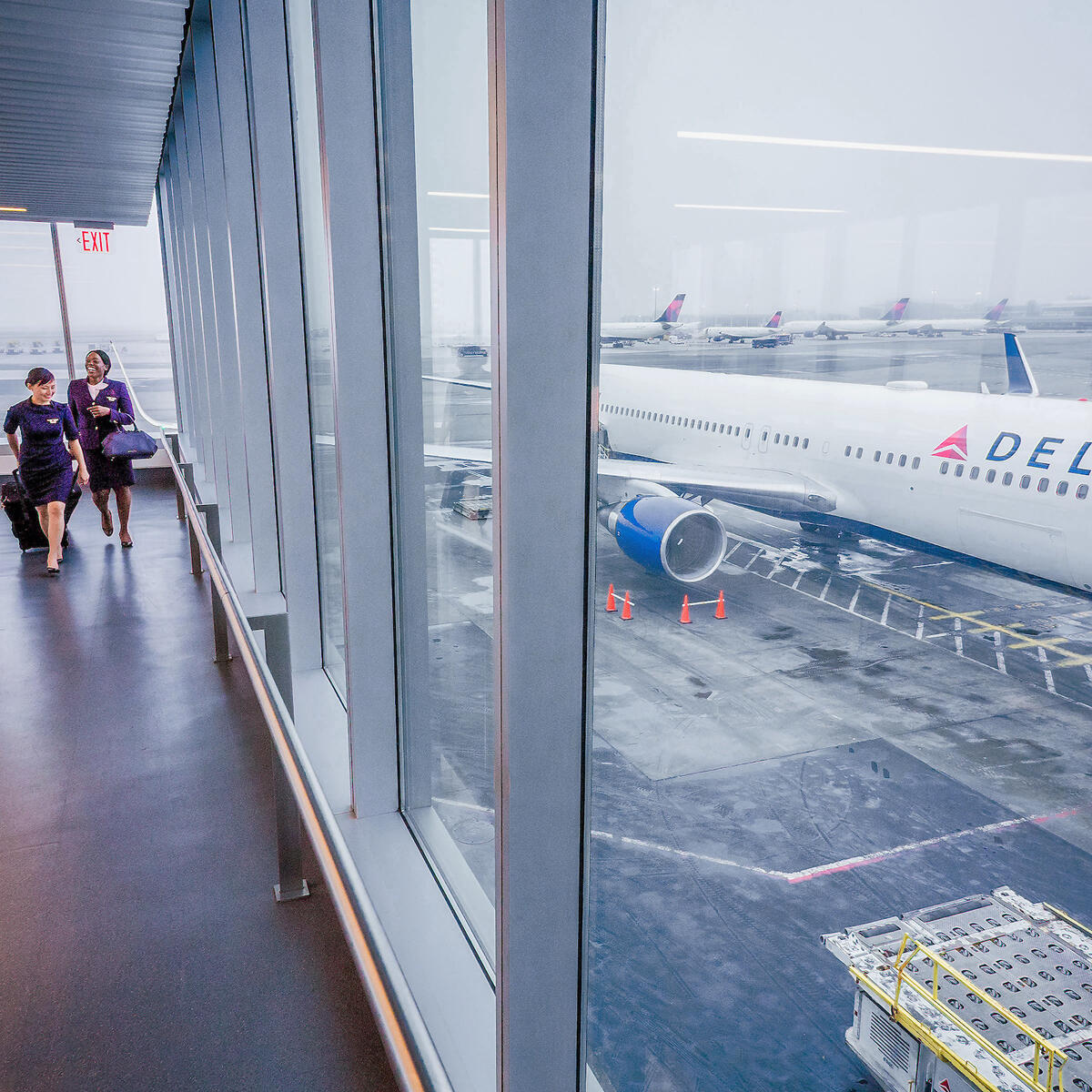 Delta flight attendants walk on a jetway at New York's John F. Kennedy International Airport.