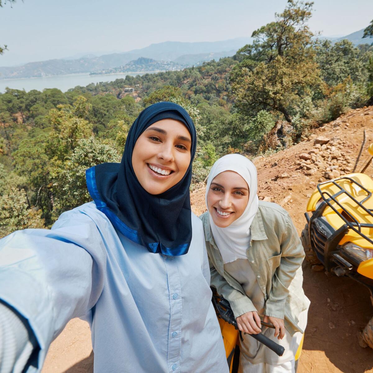 Two people pose for a selfie in front of an ATV in one of the images available as part of Delta's joint "Faces of Travel" campaign and database.