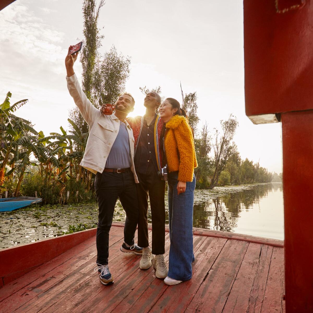Three people take a selfie on a Mexican trajinera.