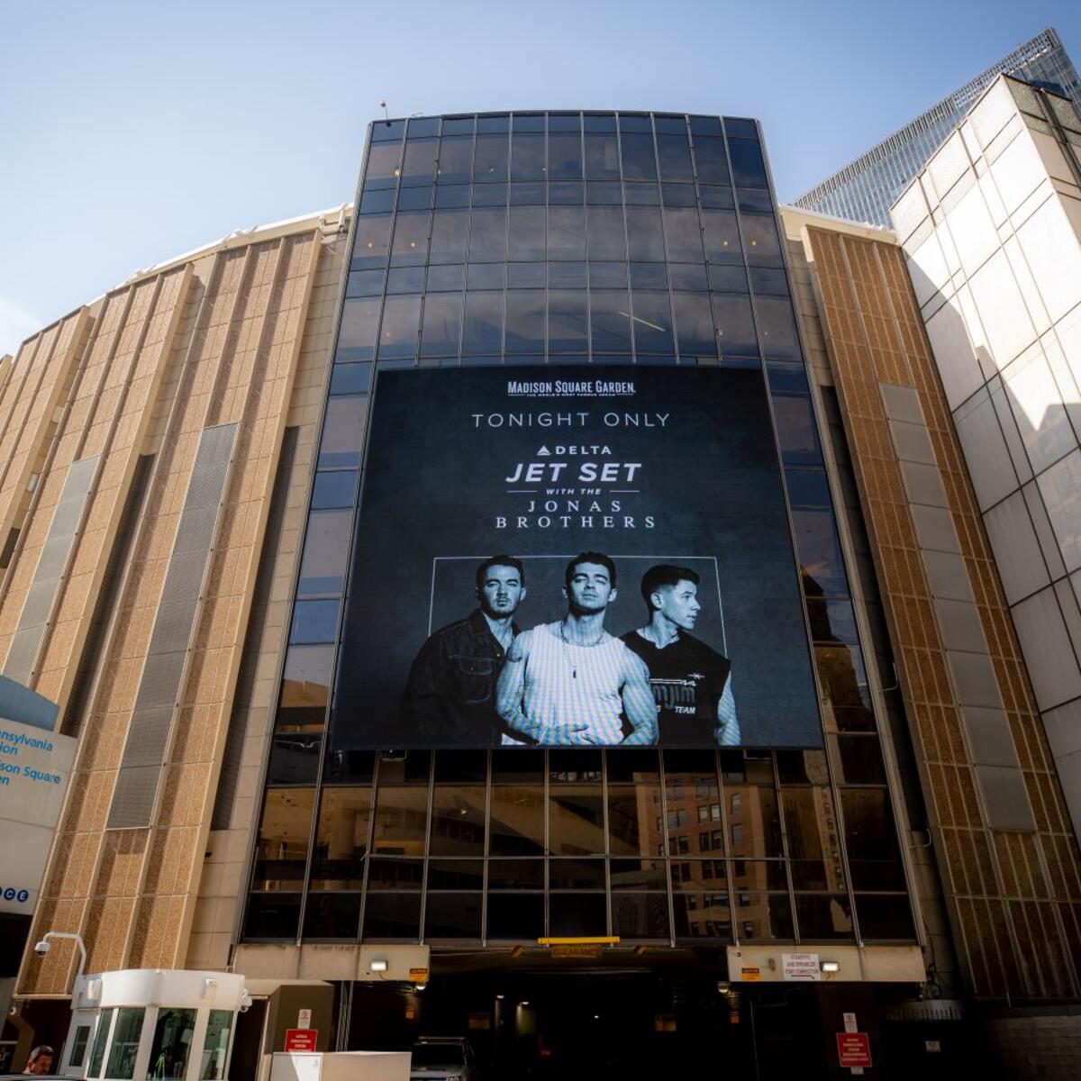A screen advertising the Jonas Brothers' concert, available on Delta Studio in October 2022, is shown outside Madison Square Garden.
