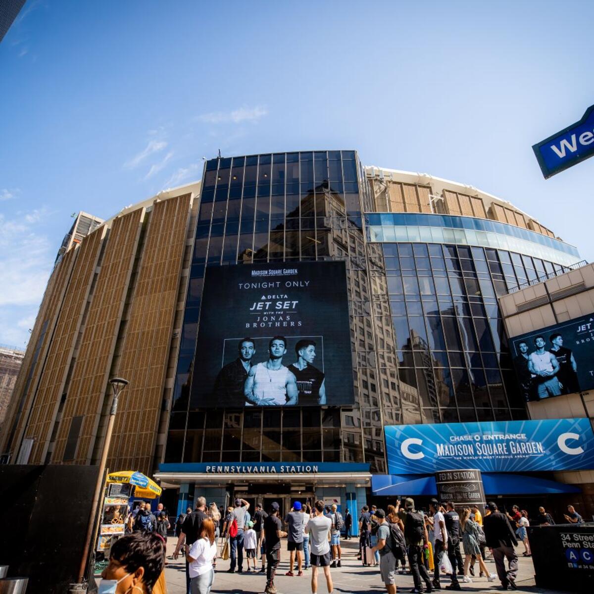 The Jonas Brothers live concert sign displayed on an outdoor screen at Madison Square Garden.