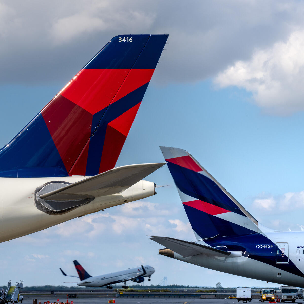 Delta and LATAM planes are shown as another plane takes off in the background in this September 2022 photo.