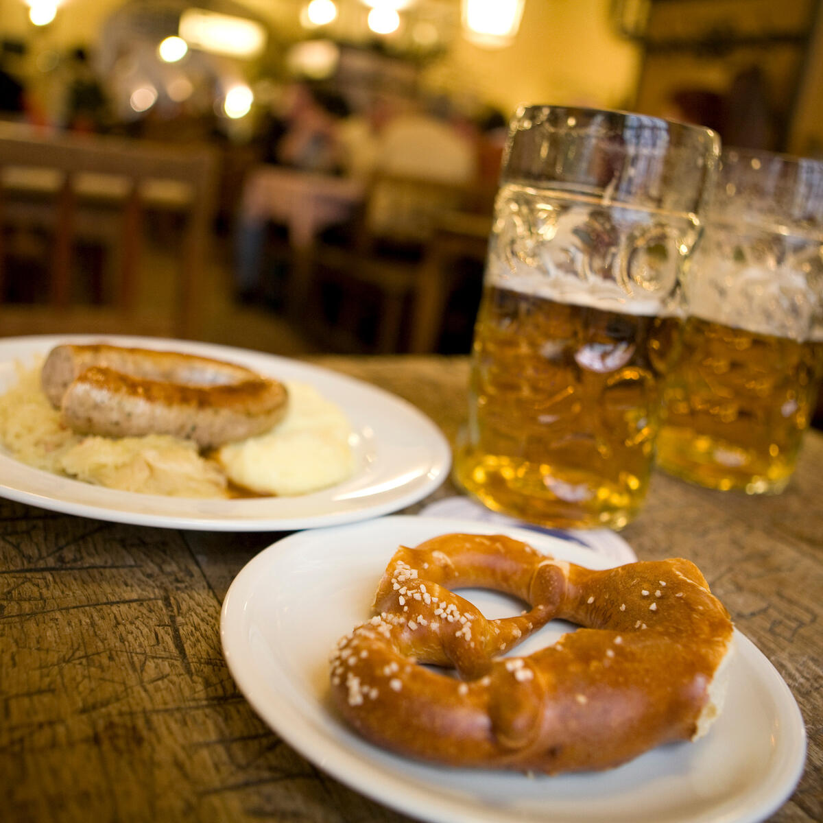 A pretzel and sausage with beer.