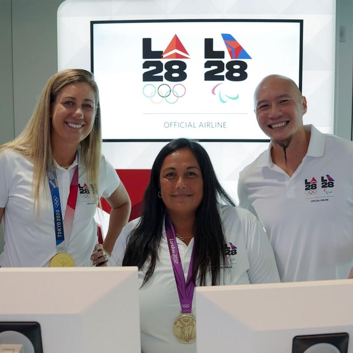 U.S. Olympians April Ross (left) and Brenda Villa (center), and U.S. Paralympian Jen Lee (right) pose for a photo at LAX near Delta's co-created LA28 logo on Sept. 29, 2022.