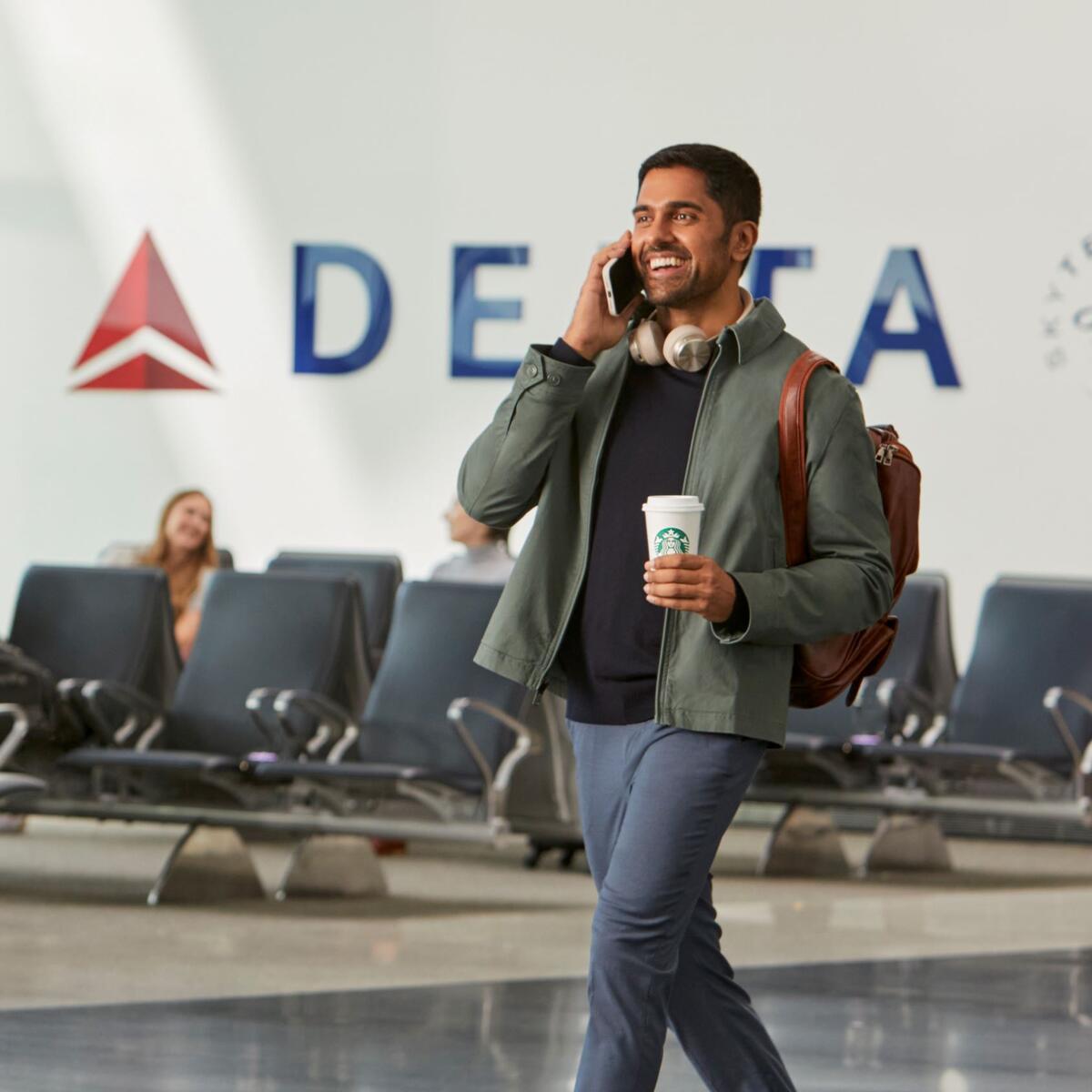 Traveler in airport enjoying Starbucks beverage