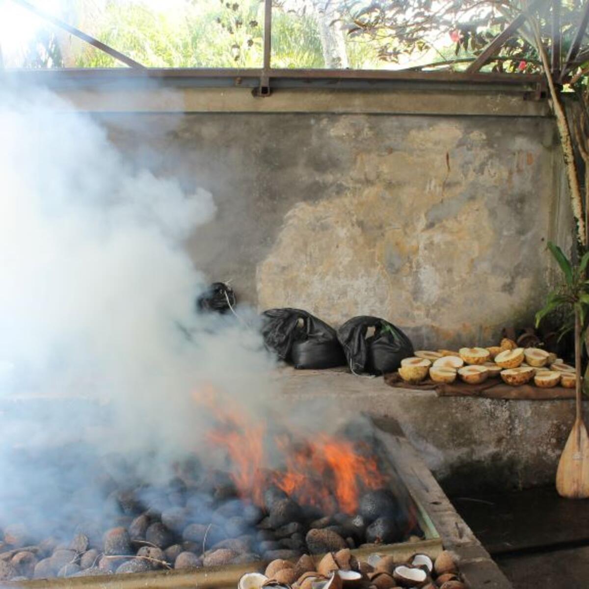 A Tahitian grilling food over an open flame