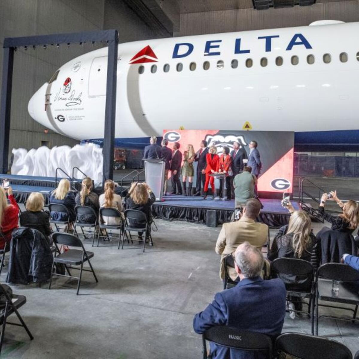 A curtain drops to reveal a memorial seal on a Delta Boeing 767-400 honoring renowned UGA football coach Vince Dooley.