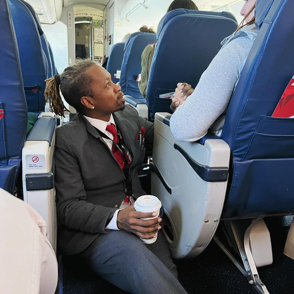 Endeavor Air flight attendant Floyd Dean-Shannon comforts a nervous customer during a Delta Connection flight from Charlotte to New York.