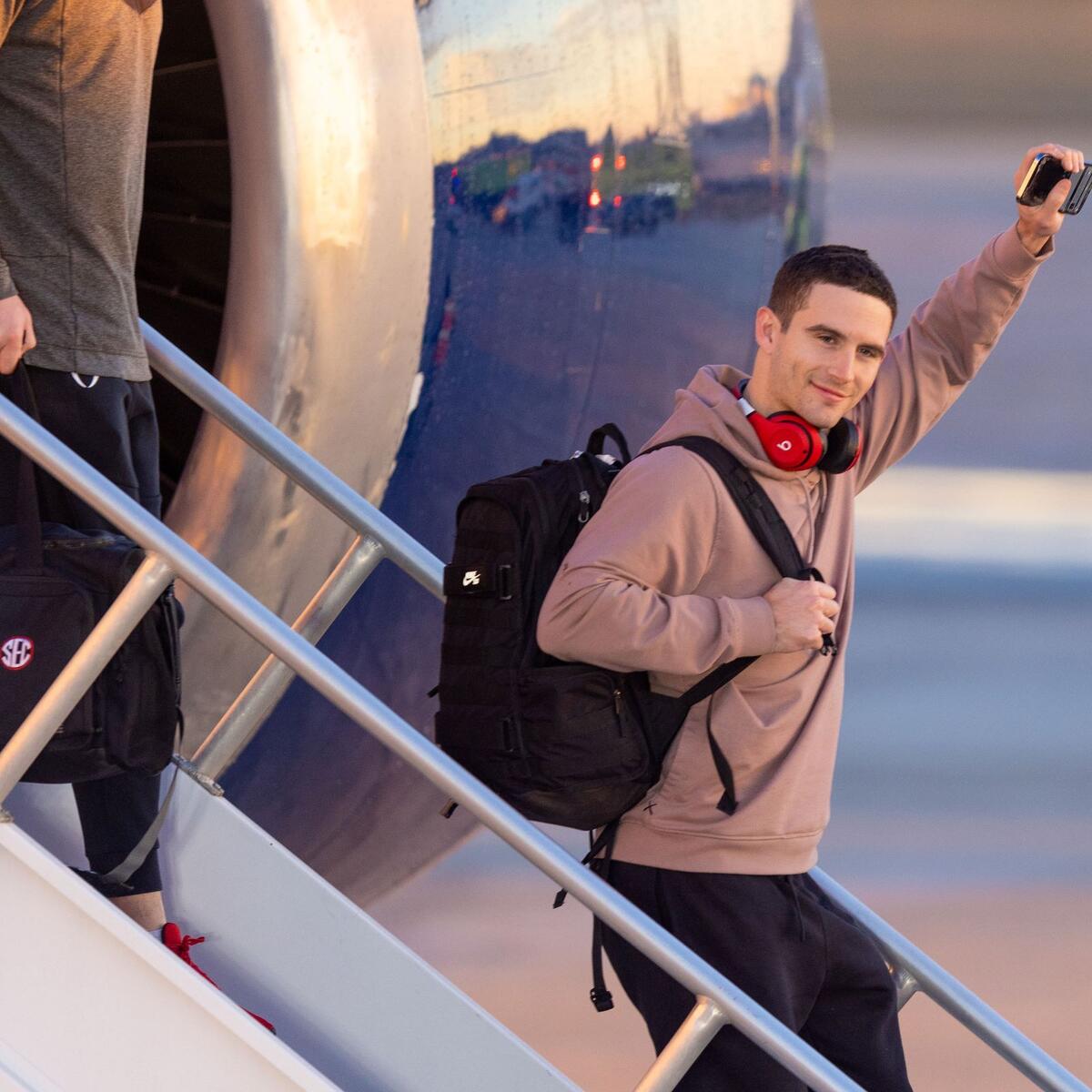 UGA quarterback Stetson Bennett gestures to the crowd as he steps off a Delta plane on Jan. 10, 2023.