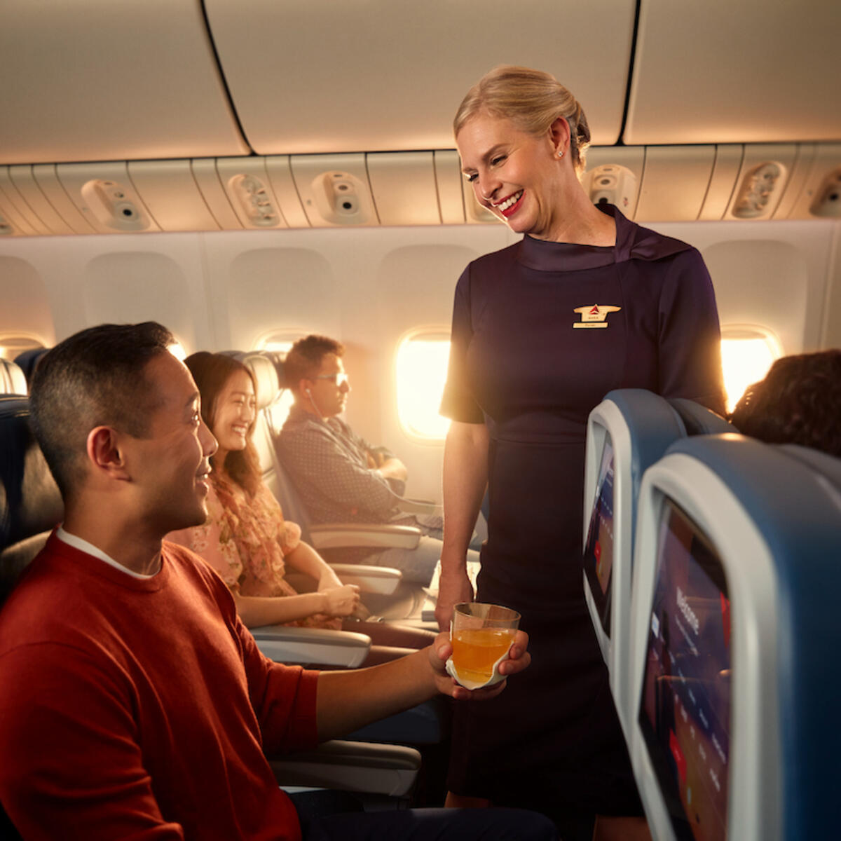 A Delta flight attendant helps a customer on board their flight.