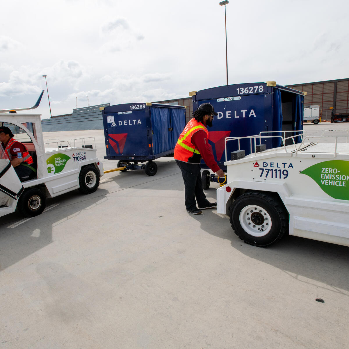 Delta Ramp Agent Sinai Pauni (left) and Aircraft Load Agent Thomas Tuikolovatu (right) operate electric bag tractors at Salt Lake City International Airport (SLC).