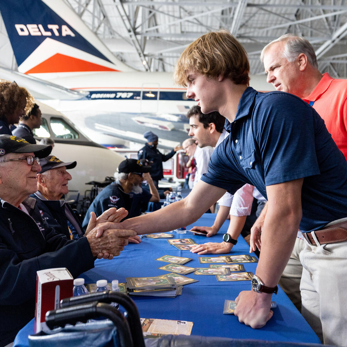 Veterans sign memorabilia and meet fans during a lunch that preceded the sendoff of more than 40 WWII veterans to Normandy, France, for the 79th annual commemoration of the 1944 D-Day invasion. 