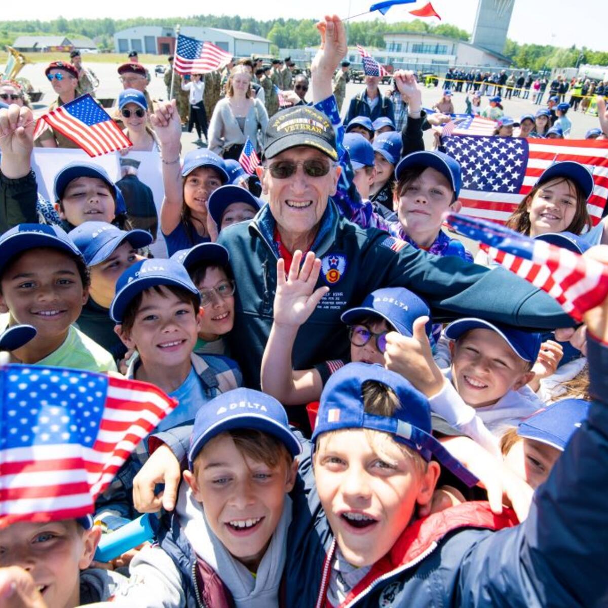 A veteran is greeted by children upon arrival in Normandy, France for the 79th annual commemoration of the 1944 D-Day invasion.