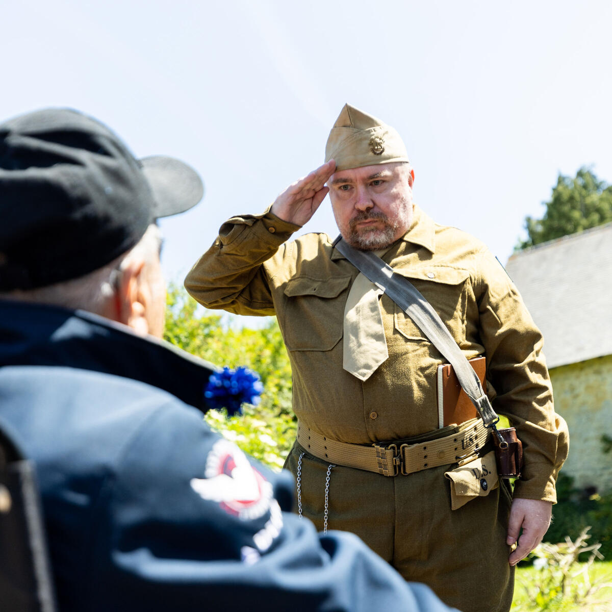 Walter Ruf salutes World War II Army veteran Andy Negra. Walter drove 11 hours to Normandy from Germany to thank a veteran for liberating his homeland and saving his mother, who faced execution under Nazi rule due to a heart condition.