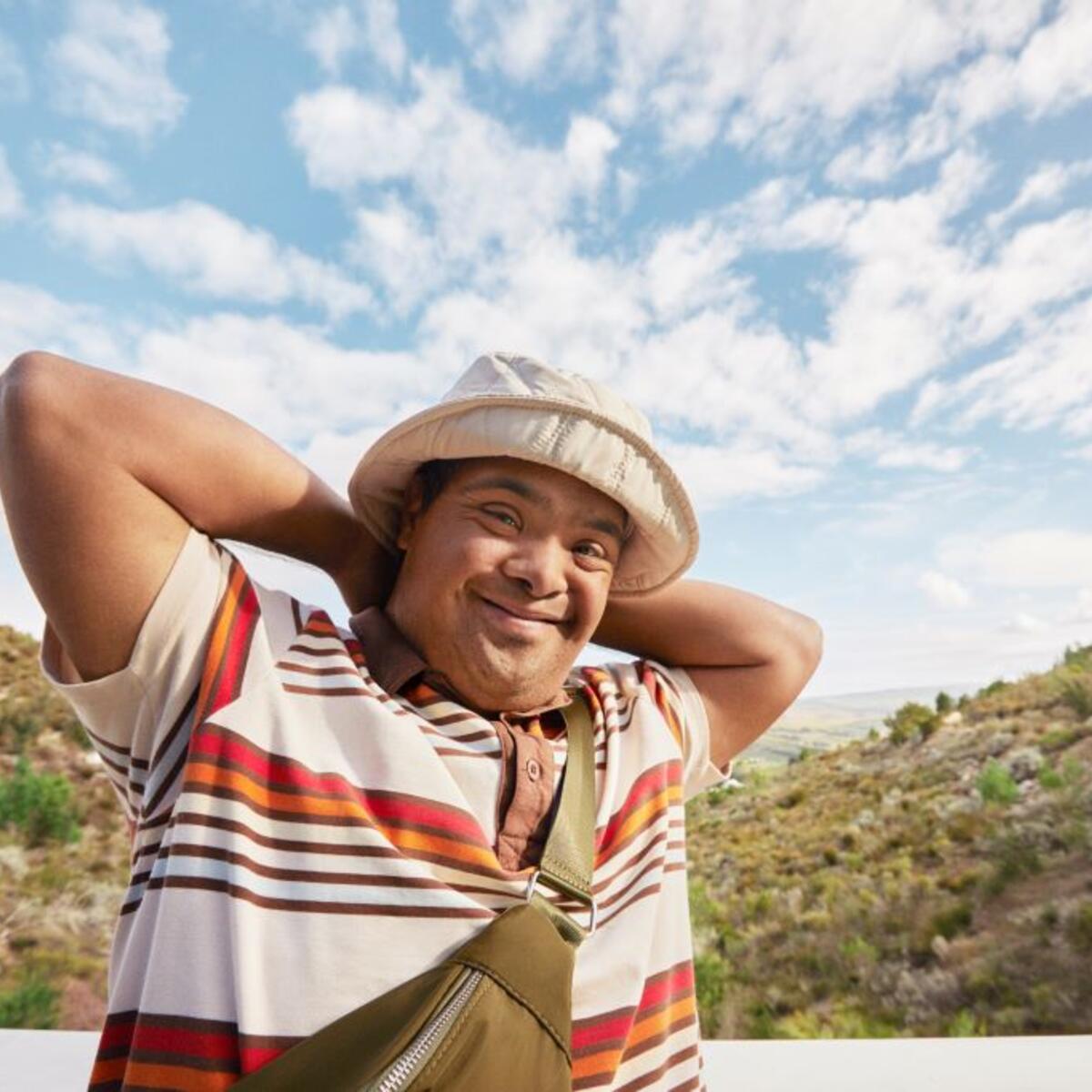A man smiles with mountains behind him