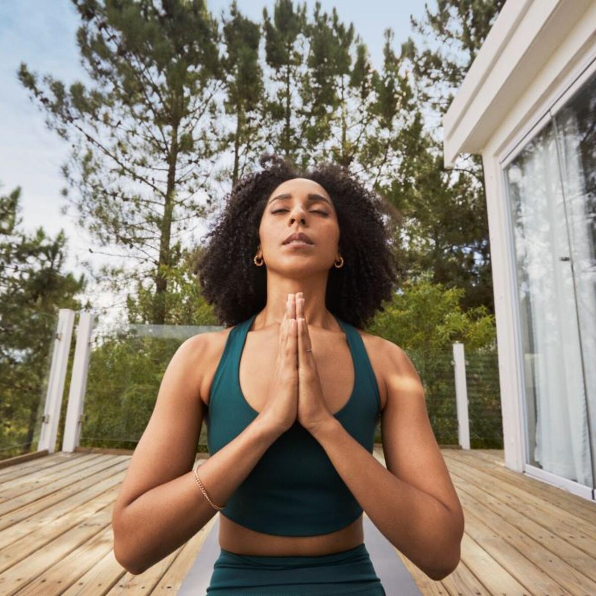 A woman practicing yoga on her back porch