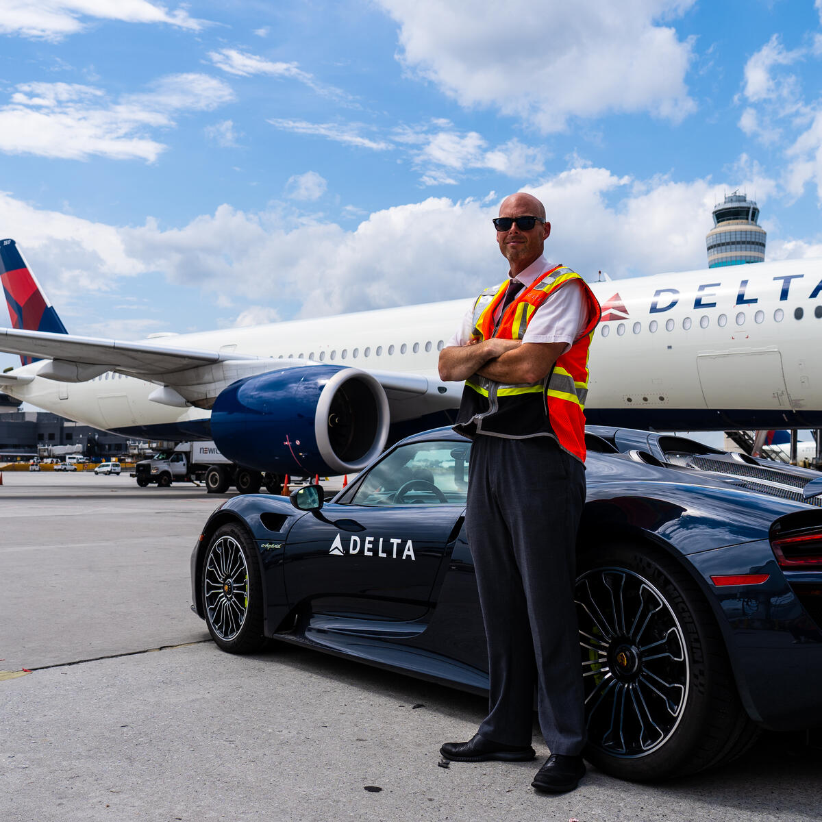 Delta Elite Services Ambassador Dan Lavker waits for a customer next to a Porsche 918 Spyder and an Airbus A350 jet at Hartsfield-Jackson Atlanta International Airport.