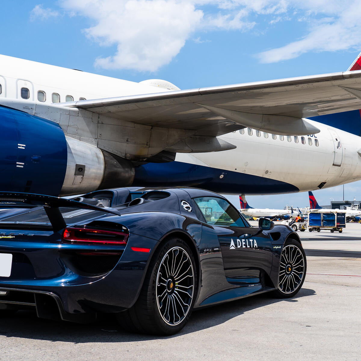 A Porsche 918 Spyder waits on the ramp to escort a Delta customer to a connecting flight. 