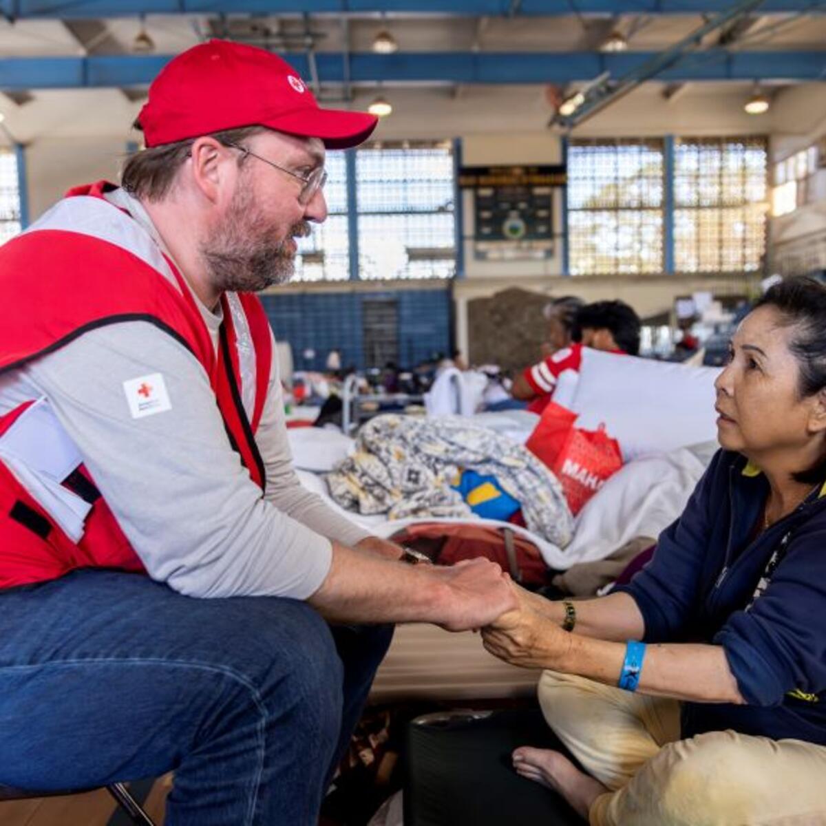American Red Cross staffer Doyle Rader holds hands with Thao Tran
