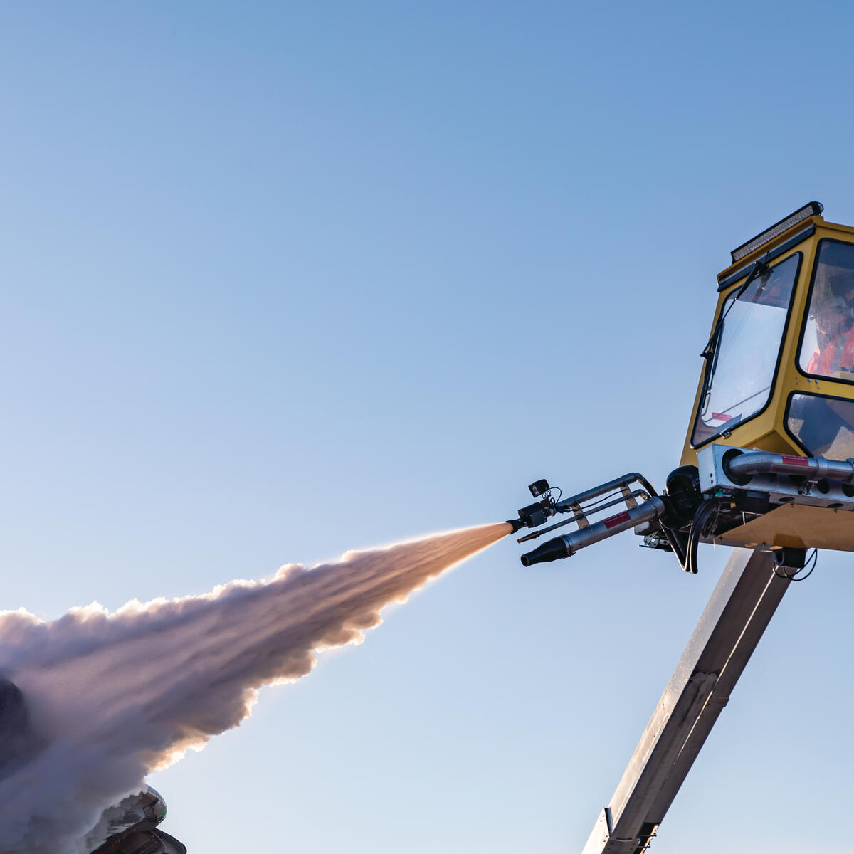 A Delta worker de-ices an airplane at Minneapolis-Saint Paul International Airport.