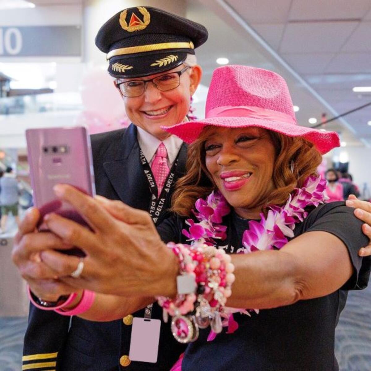 Delta employees pose for a photo before boarding Delta's Breast Cancer One charter