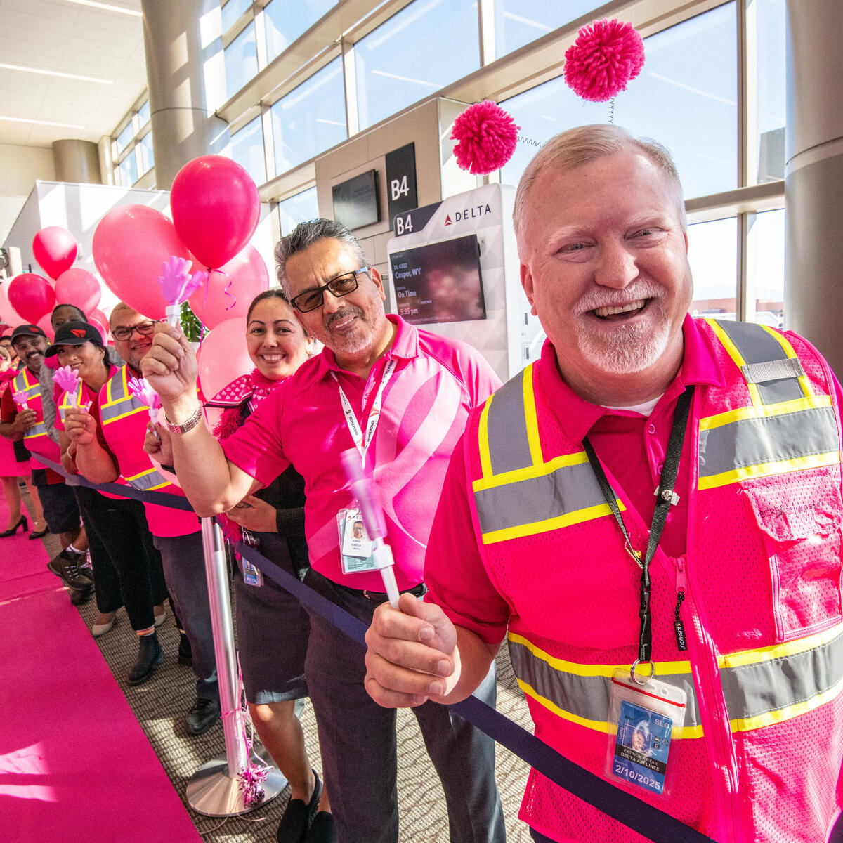 Delta people, dressed in all pink, cheer on the breast cancer survivors who flew on Delta's Breast Cancer One charter flight.