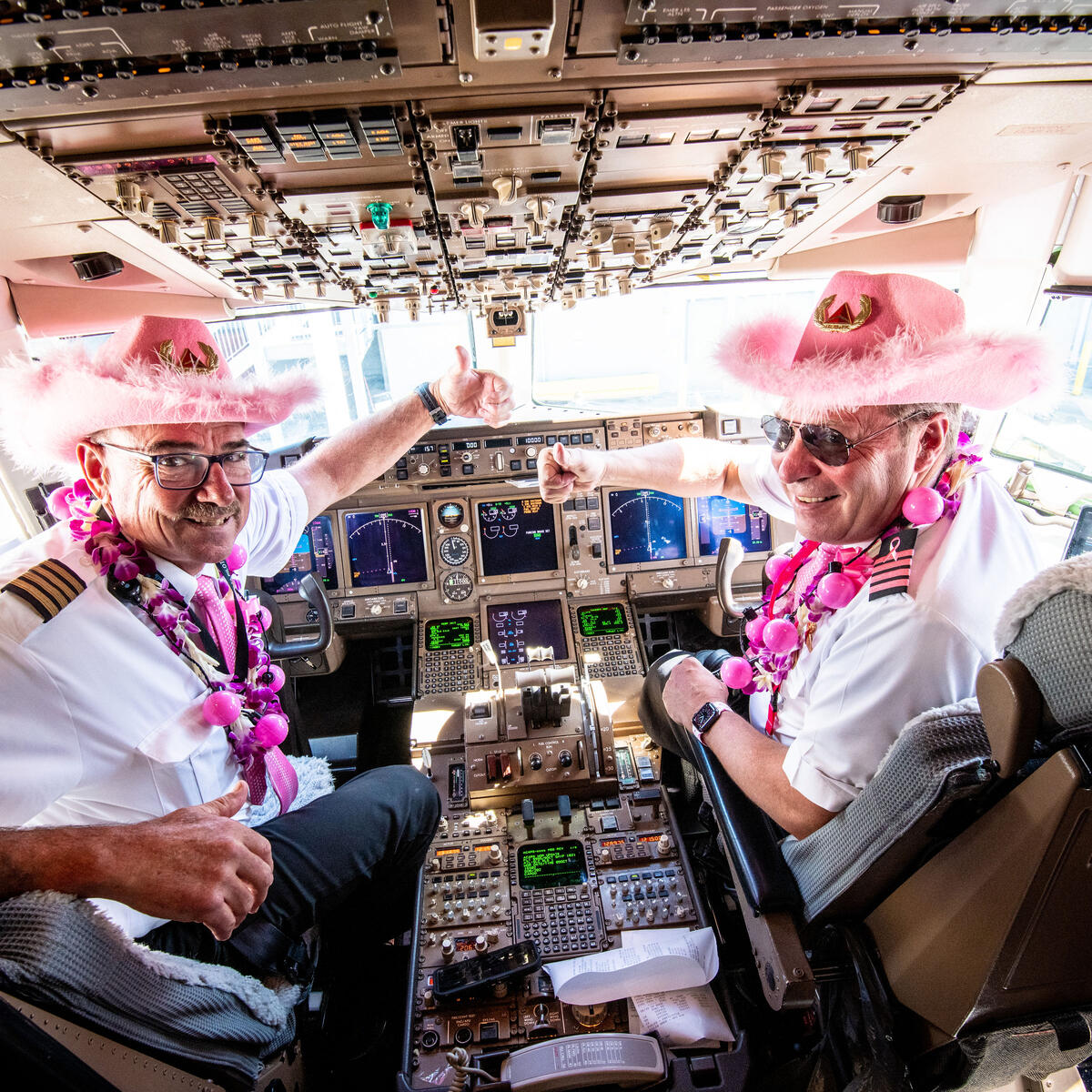 Two pilots sport all pink attire in the flight deck of the Breast Cancer One charter flight.
