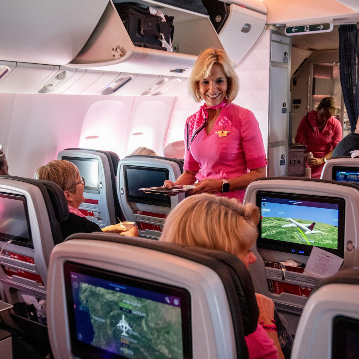 Delta leader Allison Ausband performs flight attendant duties on Delta's Breast Cancer One charter flight.