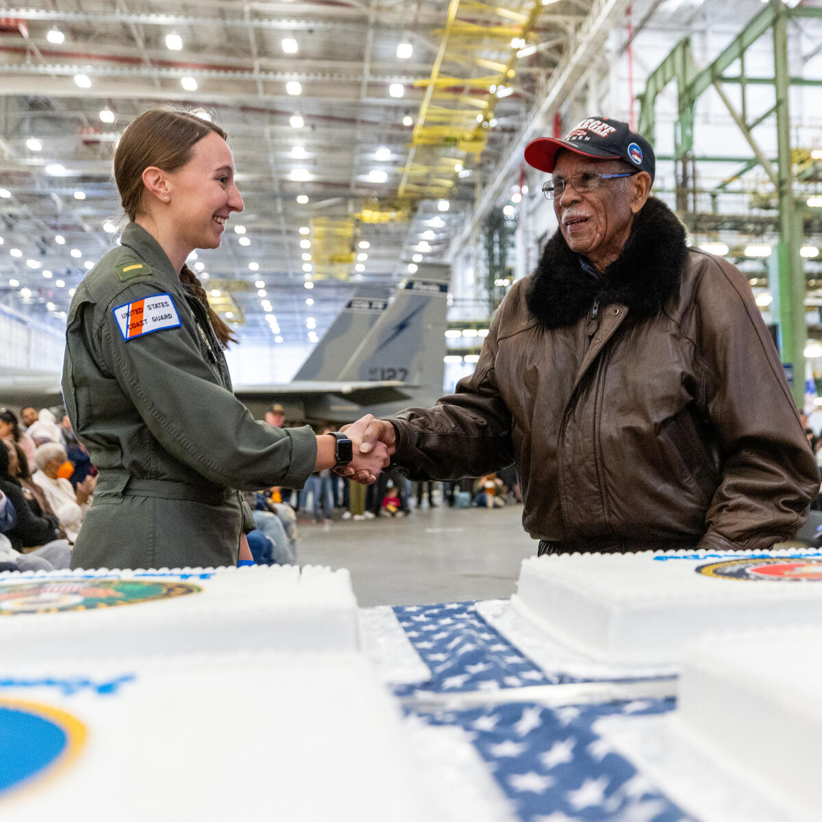 A member of the U.S. Coast Guard shakes hands with Daniel Keel, a U.S. Air Force veteran and Tuskegee Airman, at Delta's 12th annual Veterans Celebration.
