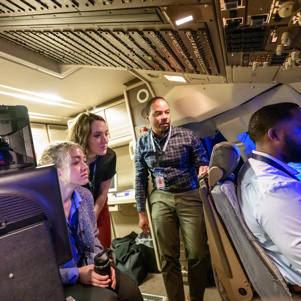 First Officer Jerome Wellons (middle) runs a flight simulator for Propel Company Path Program participants Justin Thomason, Hannah Martin and Alex Zawadzki.