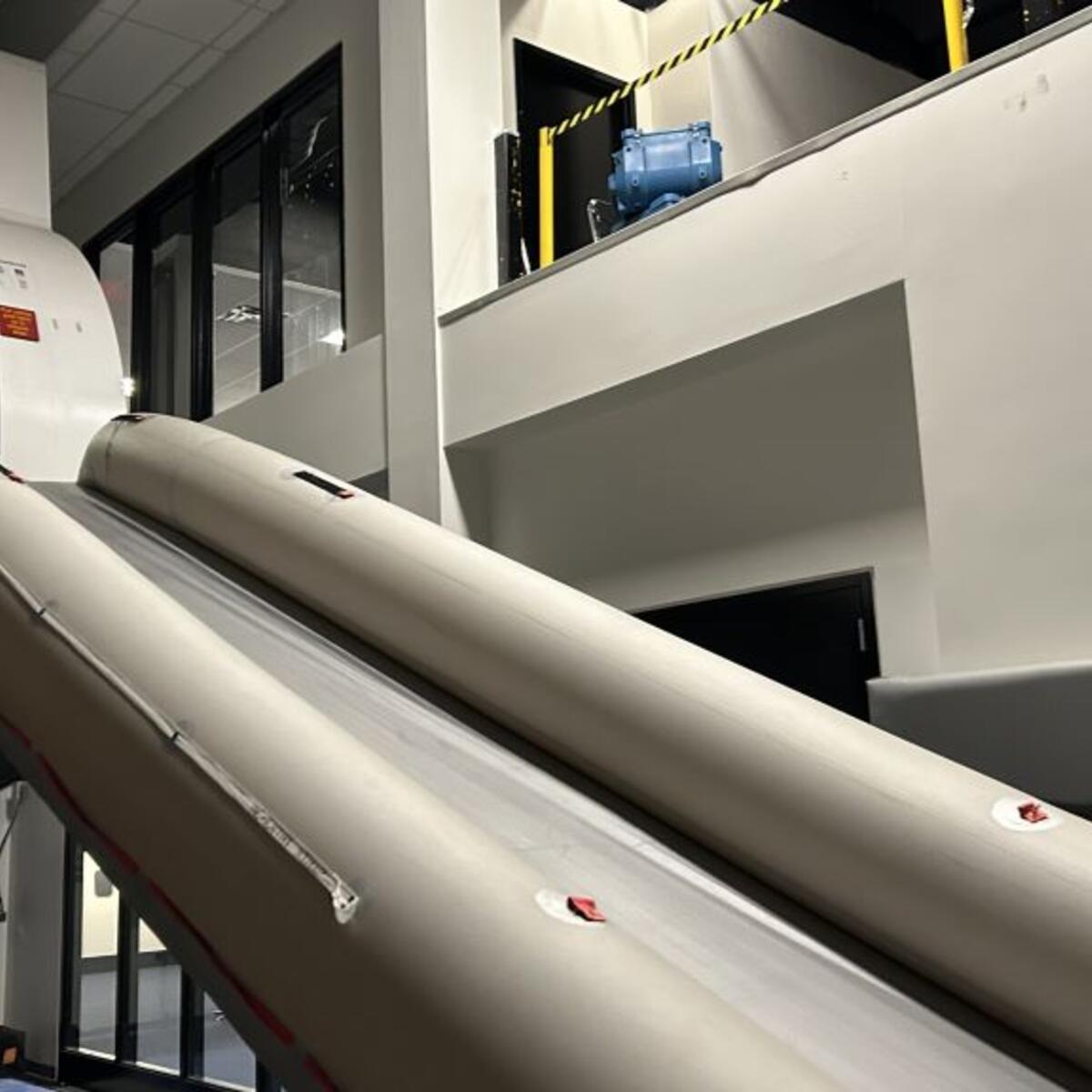 Todd O., Delta's most frequent flyer, prepares to take the plunge down the slide after an emergency flight simulator test. 