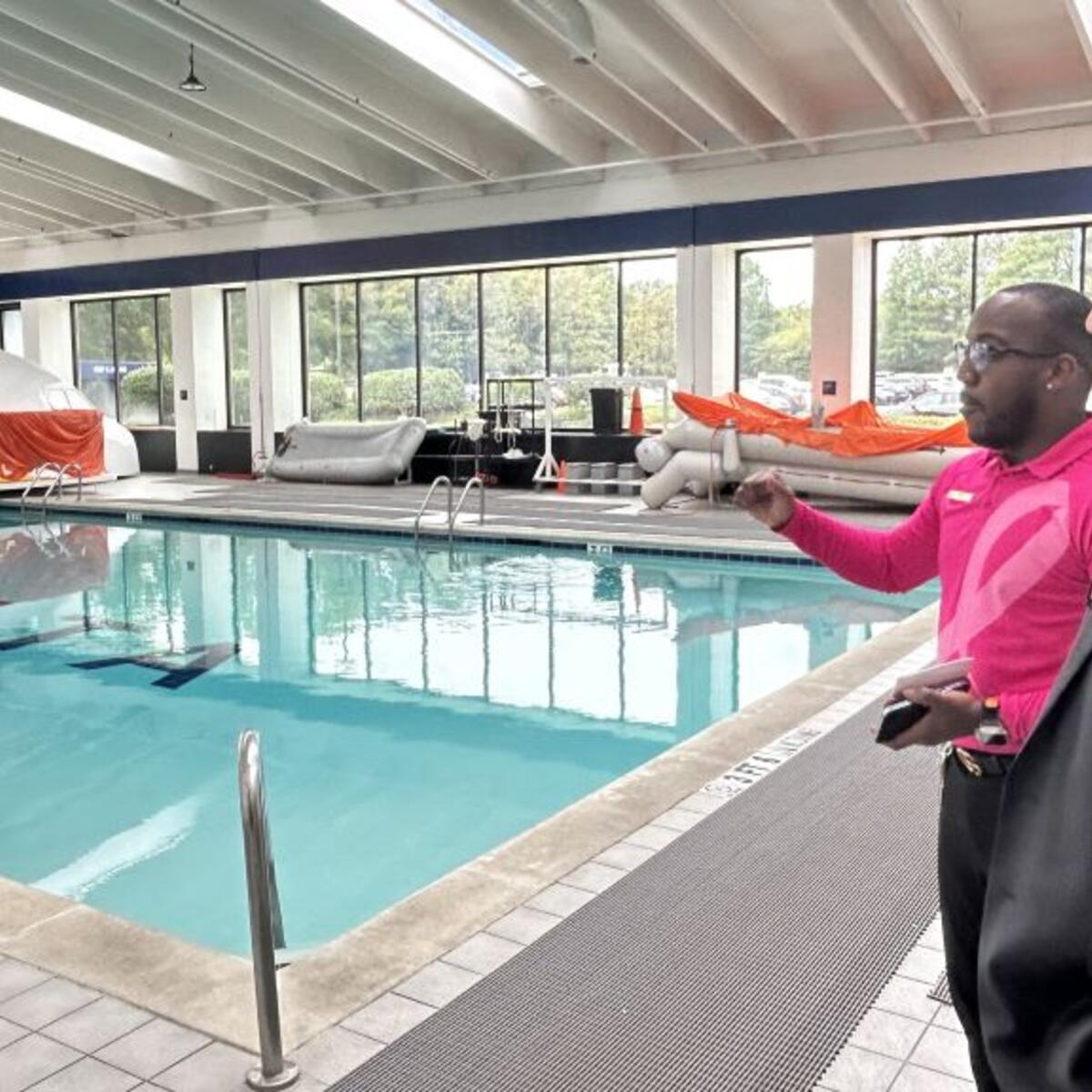 A Delta technical facilitator gives Todd O., Delta's most frequent flyer, greater insight into the rigorous flight attendant training sessions overlooking the emergency diving pool. 