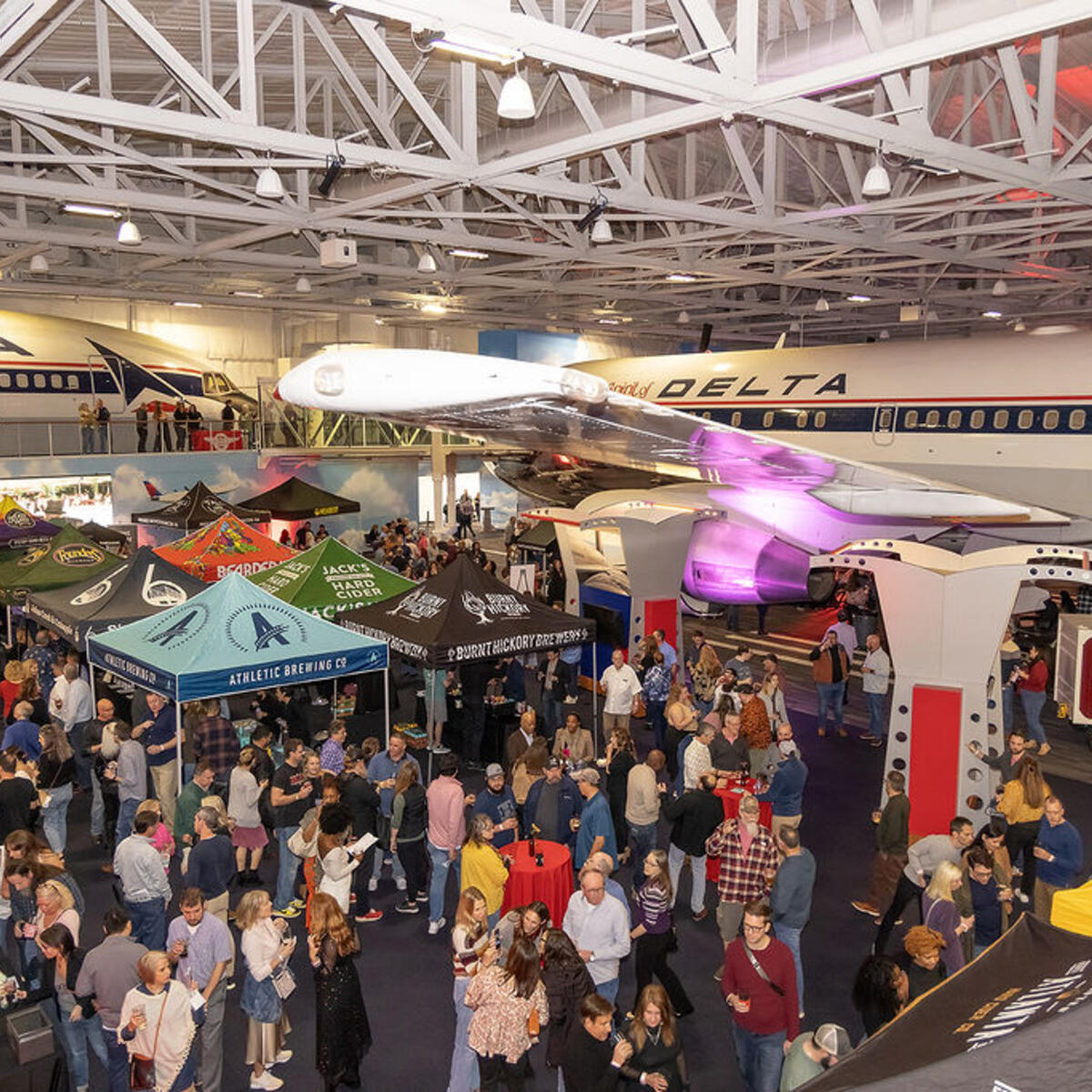 People attend the Hops in the Hangar event in the Delta Flight Museum.