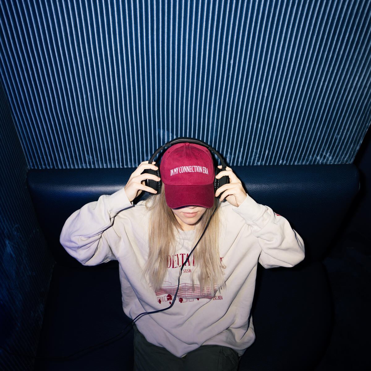A SkyMiles member enjoys the Delta Sync Space at Delta's SXSW lounge while wearing exclusive Delta x SXSW merch.&nbsp;