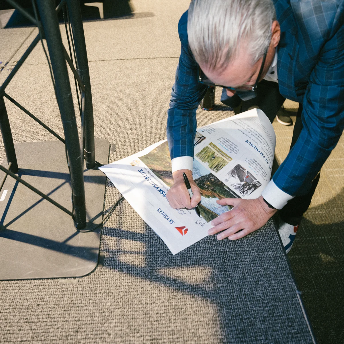 Delta CEO Ed Bastian autographs a newspaper after his panel at SXSW 2024.