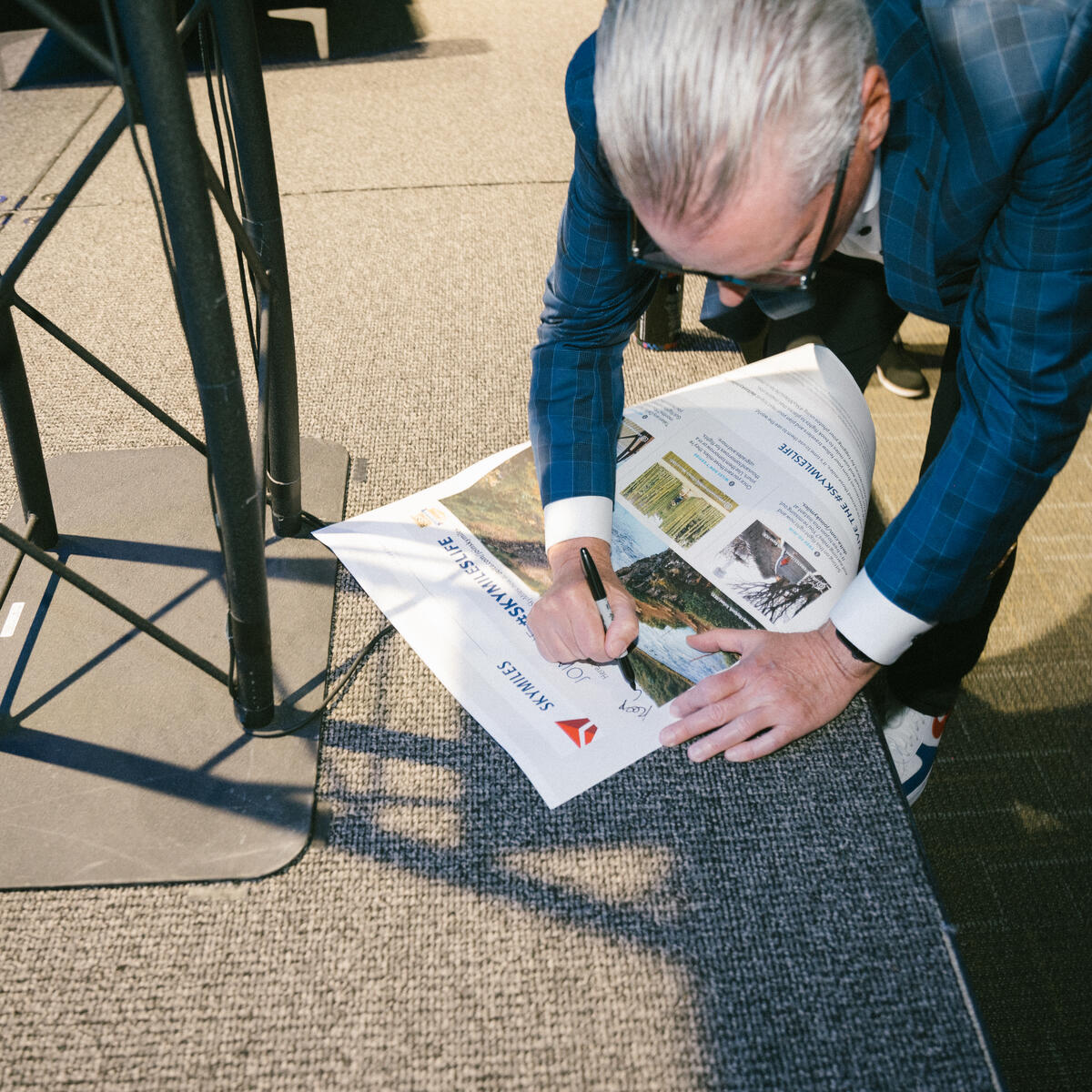Delta CEO Ed Bastian autographs a newspaper after his panel at SXSW 2024.