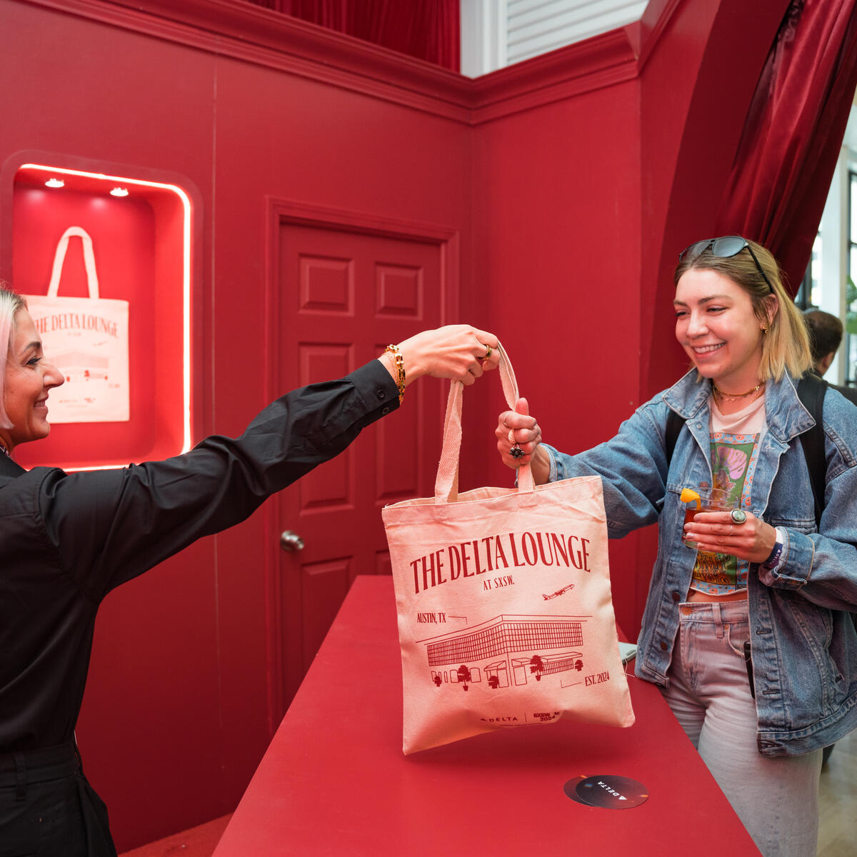 A Delta Lounge attendee receives a limited-edition Delta x SXSW canvas tote bag at the Gifting Salon during SXSW 2024.