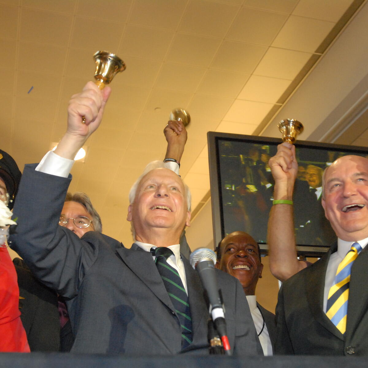 Former Delta CEO Jerry Grinstein rings a bell, signifying Delta's emergence from Chapter 11 bankruptcy.