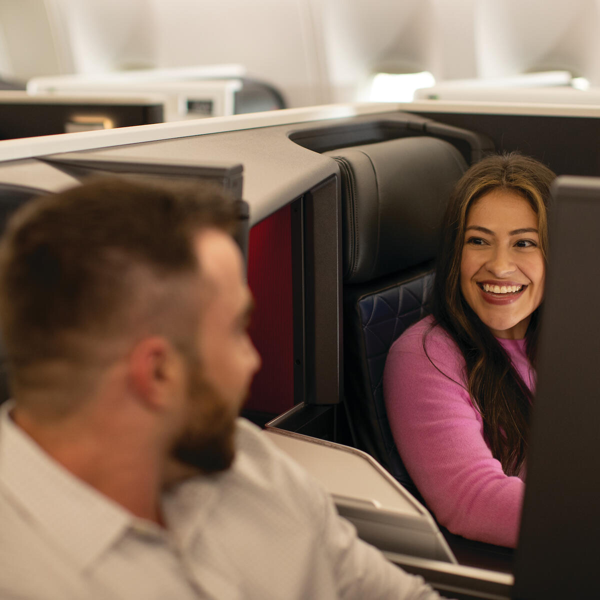 Customers sitting in Delta One smile at each other
