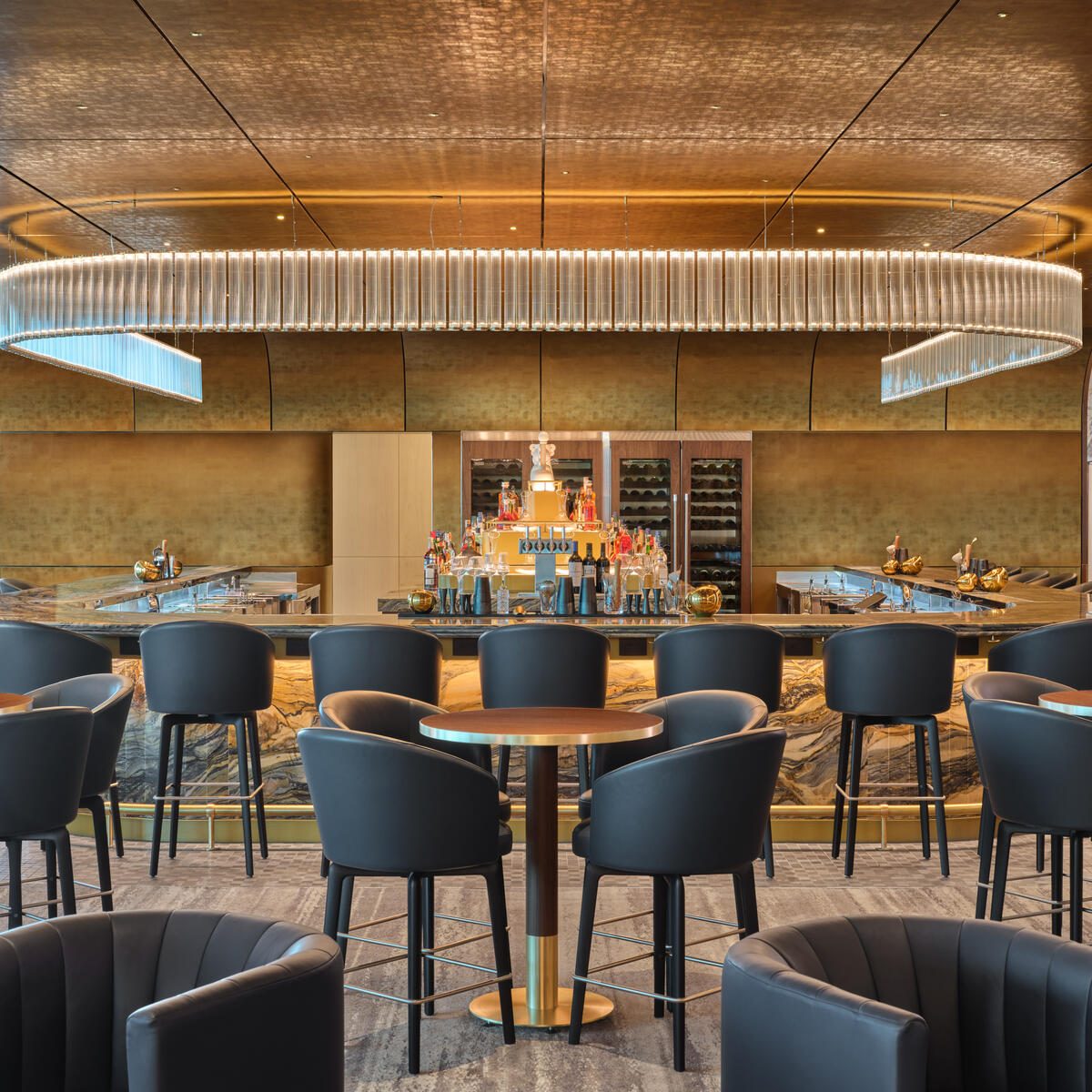 The premium bar at The Delta Lounge - JFK serves elevated takes on classic cocktails and features a standout Art Deco-inspired lighting fixture.