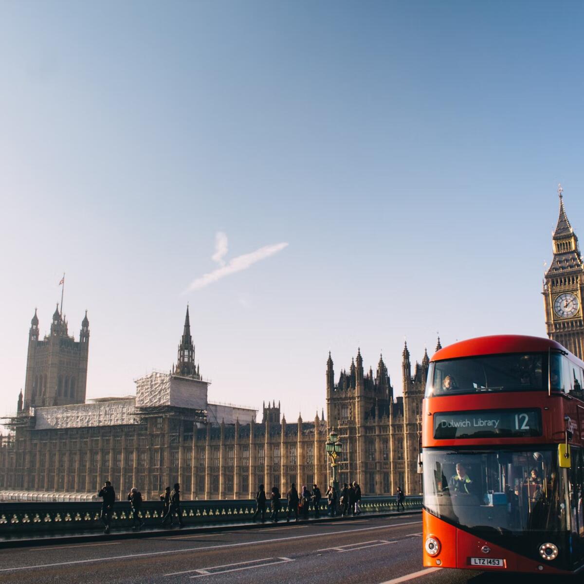 A double-decker bus rides past the Palace of Westminster in London