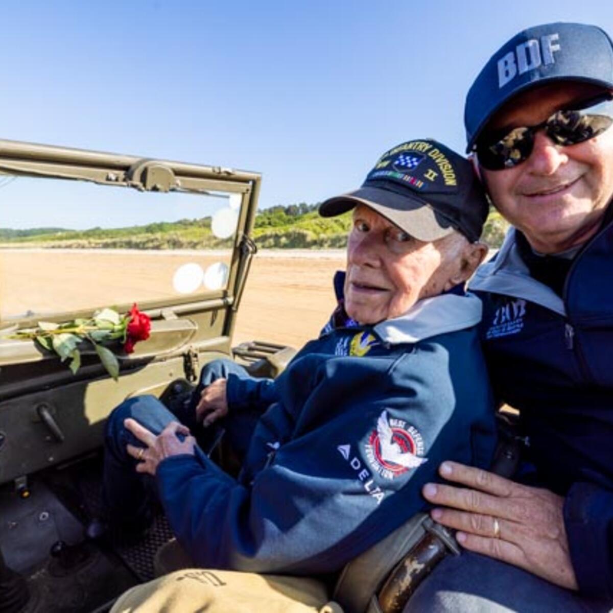 After signing countless autographs, the veterans enjoyed a ride on World War II-era vehicles to Omaha Beach, where they laid roses to remember comrades who lost their lives on those shores.