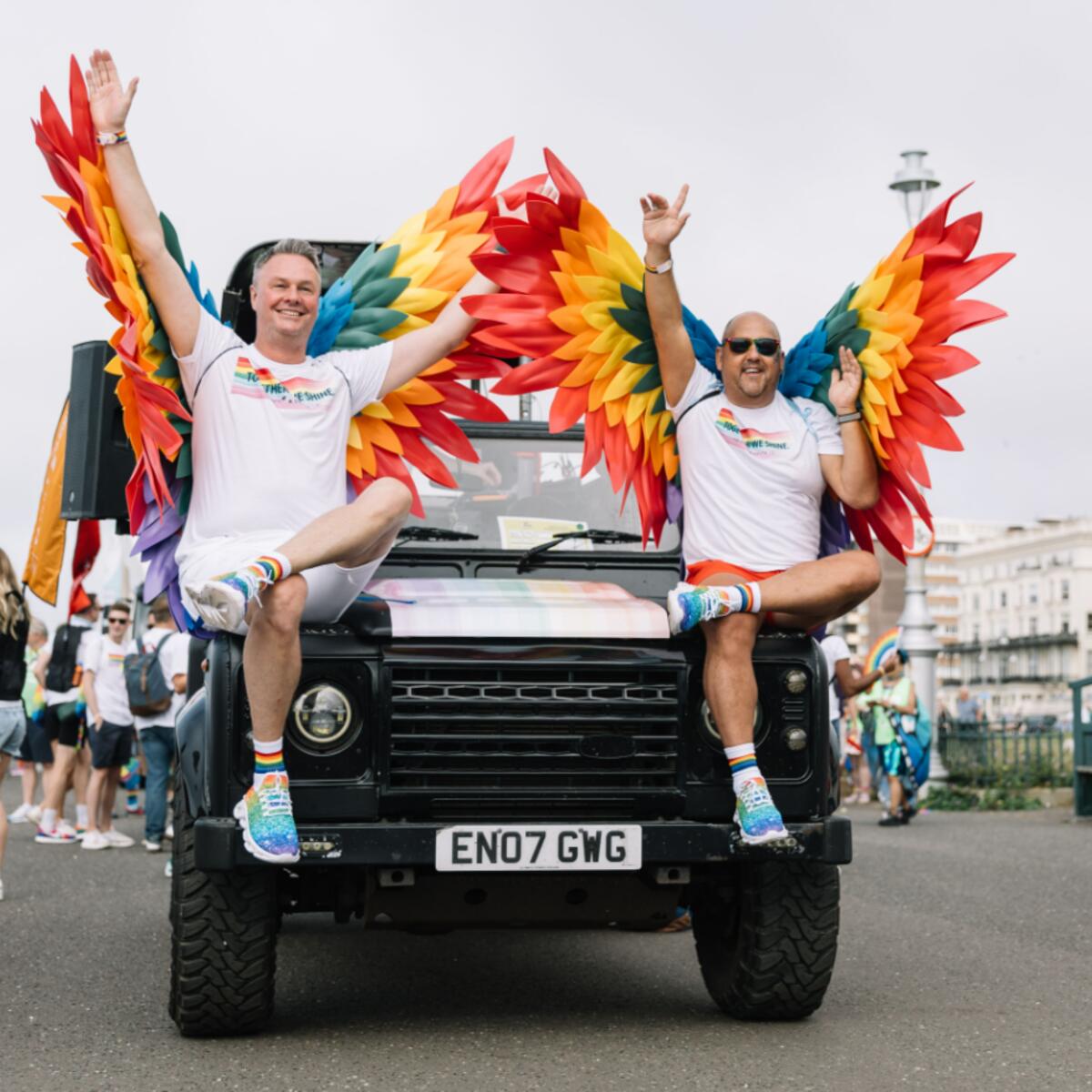 Two people wear rainbow wings for the Brighton & Hove Pride parade