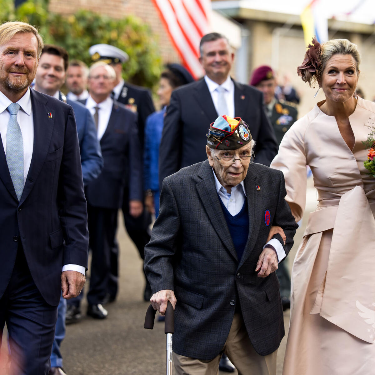 One of the six U.S. veterans that Delta flew to commemorate the liberation of the Netherlands walks with the King and Queen of the Netherlands.
