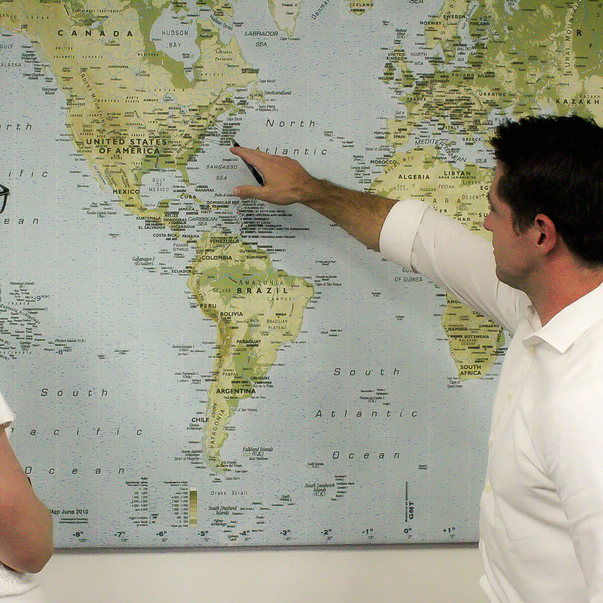 David Hart, Managing Director - Domestic Network Planning, confers with a colleague while pointing at a map.