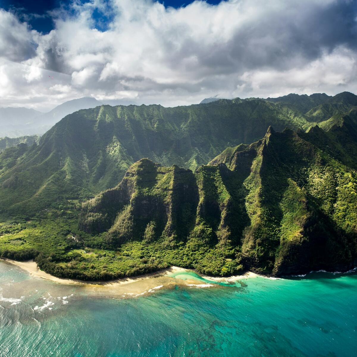 Aerial photography of green mountain beside body of water in Kauai, Hawaii
